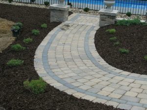 St. John Landscape Design with paver walkway leading to a pool